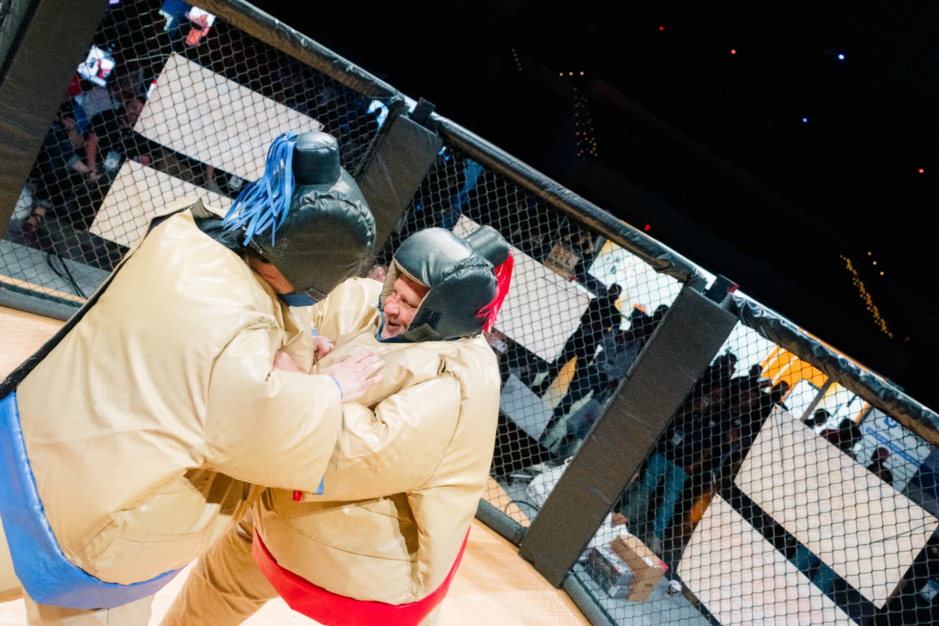 Two competitors in padded suits wrestling inside The Octagon at GRE